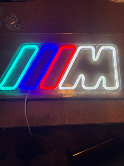 BMW M LED neon sign lit up on a desk