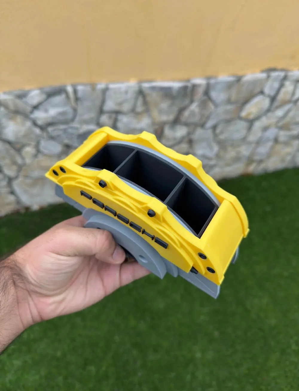 Porsche yellow brake caliper pen holder held in hand