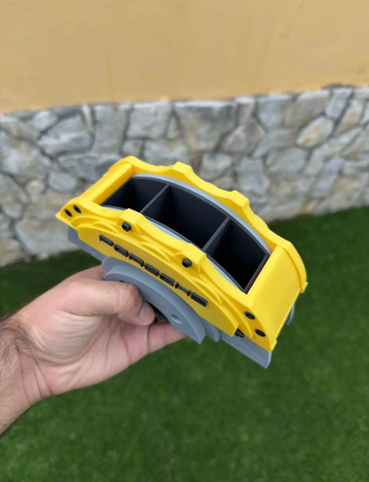 Porsche yellow brake caliper pen holder held in hand