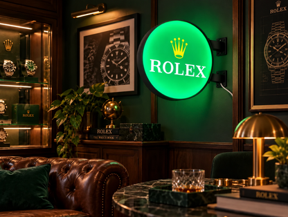 Green round light box with a gold crown mounted on a dark green wall in a watch collector's lounge