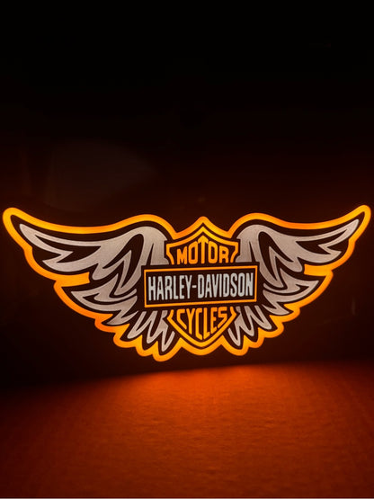 Winged motorcycle emblem light sign with orange backlight and white and black detail