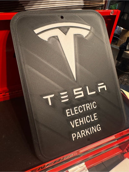White letters, logo and outline, black background, Tesla EV parking sign in a red tool chest, angled view