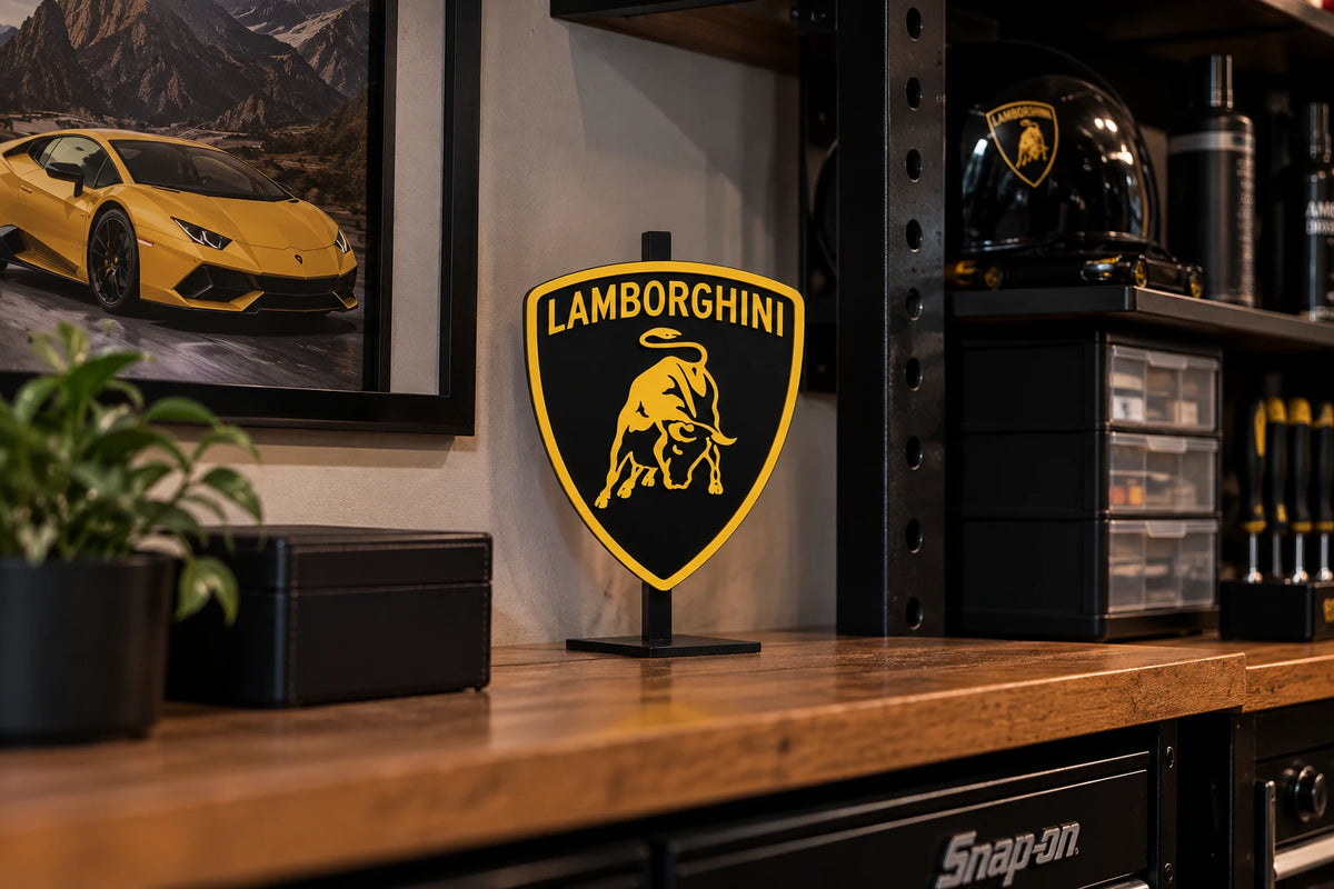 Yellow and black Lamborghini shield sign standing on a black desk stand on a garage workbench
