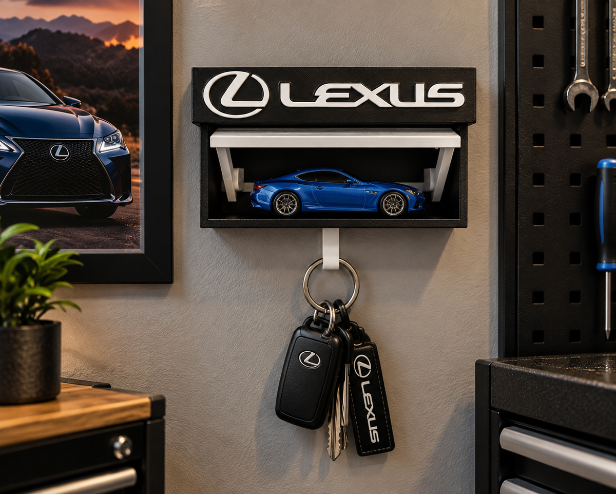 Black and white Lexus key holder on a garage wall with a blue die-cast Lexus on the shelf and keys on the hook