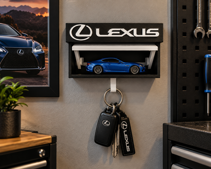 Black and white Lexus key holder on a garage wall with a blue die-cast Lexus on the shelf and keys on the hook