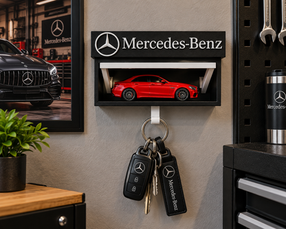 Black and white Mercedes-Benz key holder on a garage wall with a red die-cast car on the shelf and keys on the hook
