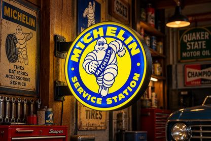 Yellow and blue Michelin Service Station round light box glowing on a wooden post in a vintage garage