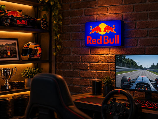 Red Bull light box glowing on a brick wall above a racing sim desk