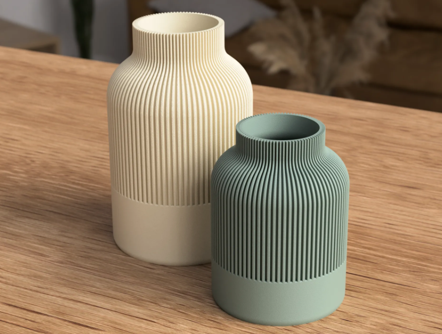 Large cream and small sage green ribbed vases on a wooden table
