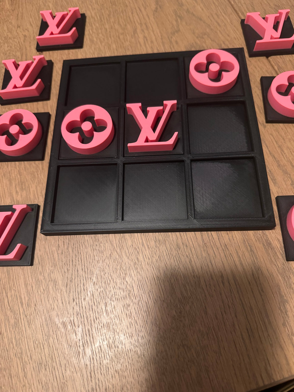 Black board with pink pieces, game in progress