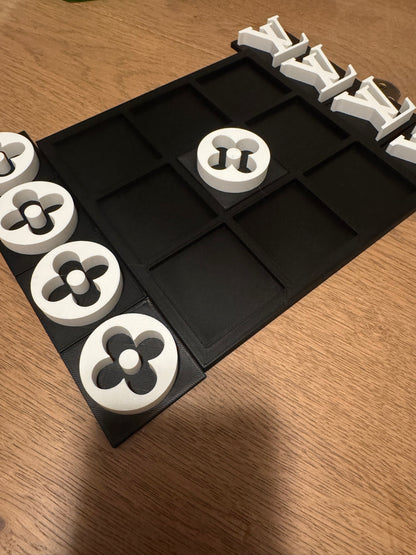 Black board with white pieces, spare pieces beside the board